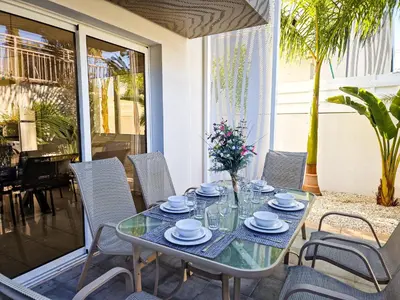 a glass table and chairs on a patio at Nissi beach villa Oleandra in Ayia Napa