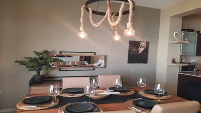 a dining room table with plates and wine glasses at Paramount Gardens Resorts C201 in Larnaka