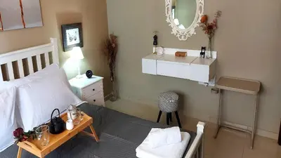 a bedroom with a bed and a table and a mirror at Paramount Gardens Resorts C202 in Larnaka