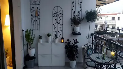 a balcony with potted plants and a table and chairs at Paramount Gardens Resorts C202 in Larnaka