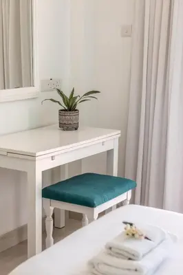 a white table with a green bench and a mirror at Mia Hotel Apartment in Ayia Napa