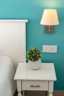 a white table with a lamp and a plant on it at Mia Hotel Apartment in Ayia Napa