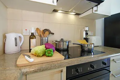 a kitchen counter with a cutting board with vegetables on it at VERONICA - Coralli Beachfront Apartment in Protaras