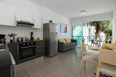 a kitchen and living room with a couch and a table at Niovi - Coralli Beachfront Apartment in Protaras