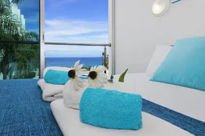 a bedroom with a bed with blue and white pillows at Niovi - Coralli Beachfront Apartment in Protaras