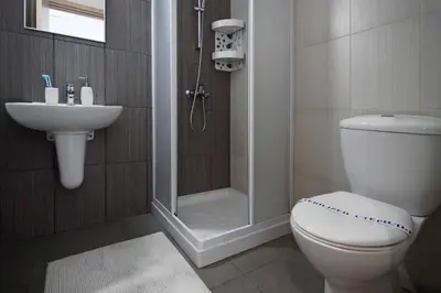 a bathroom with a shower and a toilet and a sink at Niovi - Coralli Beachfront Apartment in Protaras