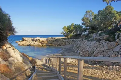 a set of stairs leading to a beach with the ocean at Niovi - Coralli Beachfront Apartment in Protaras