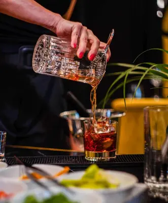 a person pouring a drink into a glass at Gate Twenty Two Boutique Hotel in Nicosia