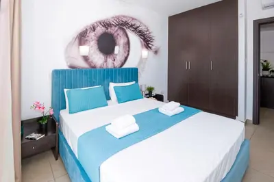 a bedroom with a blue and white bed with towels on it at SHARON - Coralli Beachfront Apartment in Protaras