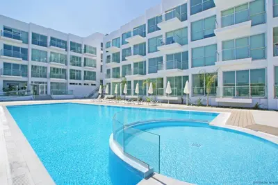 a large swimming pool in front of a building at GABRIELA - Coralli Beachfront Apartment in Protaras