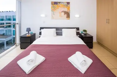 a bedroom with a large bed with white towels on it at LAILA - Coralli Beachfront Apartment in Protaras