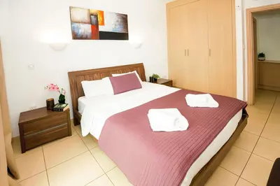 a bedroom with a large bed with two towels on it at BLISS - Coralli Beachfront Apartment in Protaras