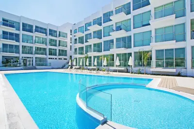 a large swimming pool in front of a building at DIANA - Coralli Beachfront Apartment in Protaras
