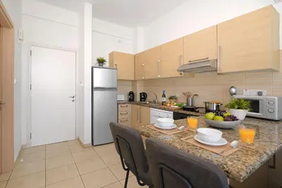 a kitchen with a island with a table with chairs at MERYL - Coralli Beachfront Apartment in Protaras