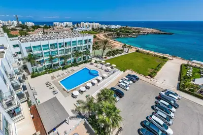 an aerial view of a resort with a pool and a parking lot at MERYL - Coralli Beachfront Apartment in Protaras