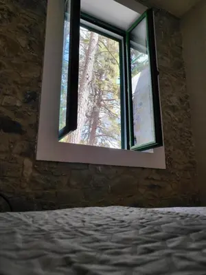 a bedroom with a window in a stone wall at ThePlatres.Nest in Platres