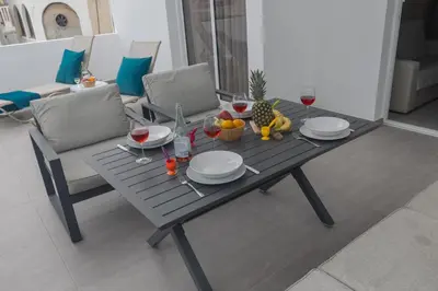 a table with glasses of wine and fruit on it at Evas Apartment in Protaras