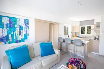 a living room with a white couch and blue pillows at Evas Apartment in Protaras