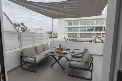a balcony with a table and chairs and a building at Evas Apartment in Protaras
