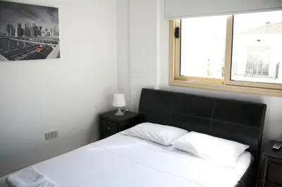 a bedroom with a white bed and a window at Palm Tree Villas in Protaras