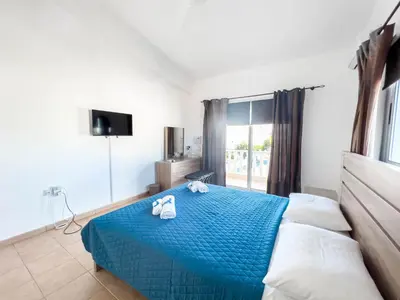 a bedroom with a blue bed with towels on it at FAME villa with Private Pool and Gazebo in Ayia Napa