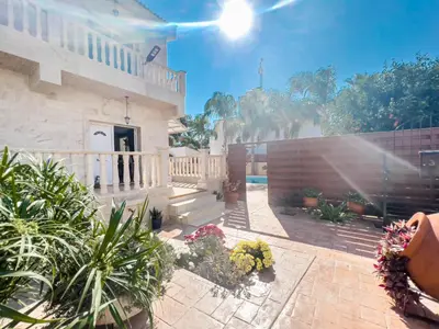 a house with a patio with flowers and a fence at FAME villa with Private Pool and Gazebo in Ayia Napa