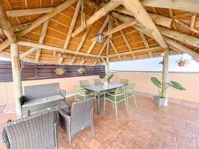 a patio with a table and chairs under a wooden roof at FAME villa with Private Pool and Gazebo in Ayia Napa