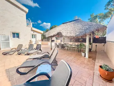 a group of chairs and an umbrella on a patio at FAME villa with Private Pool and Gazebo in Ayia Napa