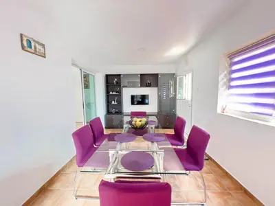 a dining room with purple chairs and a glass table at FAME villa with Private Pool and Gazebo in Ayia Napa