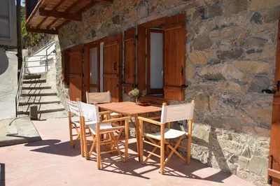 a wooden table and chairs outside of a stone building at Konatzin tou Massou by Raise in Moutoullas