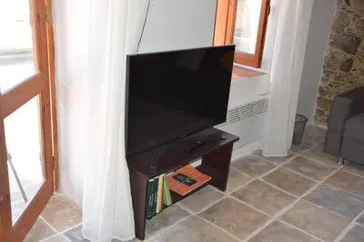 a flat screen tv on a stand in a living room at Konatzin tou Massou by Raise in Moutoullas