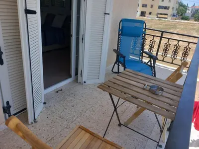 a wooden bench on a balcony with a bed at Vasilis house in Mor Menekshe
