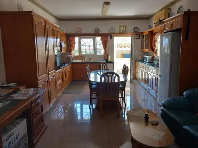 a kitchen with a table and a kitchen with a refrigerator at Vasilis house in Mor Menekshe