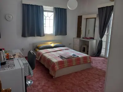 a bedroom with a bed and a dresser and a mirror at Vasilis house in Mor Menekshe