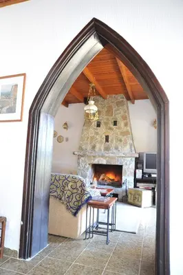 an archway in a living room with a stone fireplace at IRENE cottage in Kakopetria