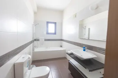 a white bathroom with a sink and a toilet at Sparta Luxury Villa in Protaras