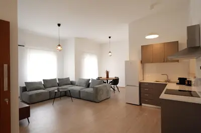 a living room with a couch and a table in a kitchen at Maison Zenon Larnaca City Center apartments in Larnaka
