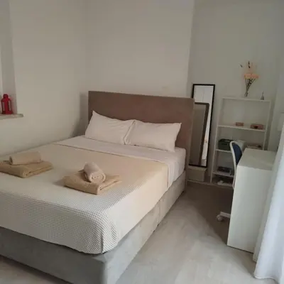 a bedroom with a bed with towels on it at Maison Zenon Larnaca City Center apartments in Larnaka
