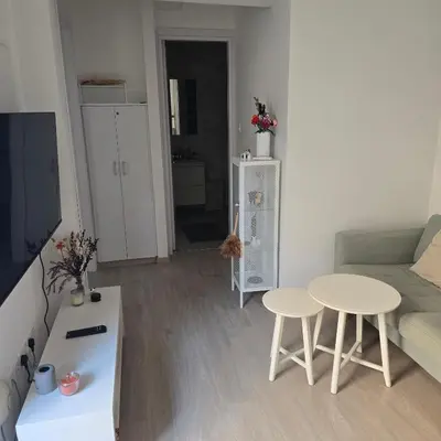 a living room with a couch and a table and chairs at Maison Zenon Larnaca City Center apartments in Larnaka
