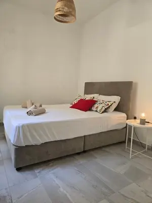 a bed with two pillows on it in a room at Maison Zenon Larnaca City Center apartments in Larnaka