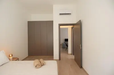 a bedroom with two beds and an open door at Maison Zenon Larnaca City Center apartments in Larnaka