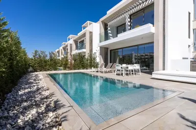a swimming pool in front of a house at Waves 3-Bedroom Villa in Protaras in Paralimni