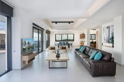 a living room with a leather couch and a table at The Oasis in Protaras