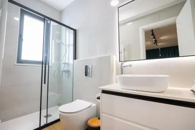 a white bathroom with a sink and a shower at The Oasis in Protaras