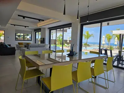 a dining room and living room with a table and chairs at The Oasis in Protaras