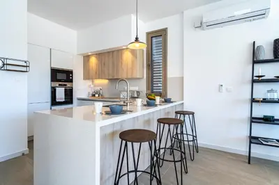 a kitchen with a island with bar stools at Cyan 3-Bedroom Villa in Protaras in Paralimni