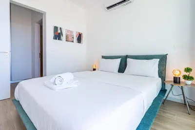 a large white bed in a room with a table at Cyan 3-Bedroom Villa in Protaras in Paralimni