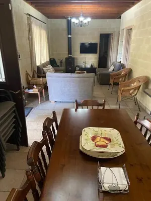 a room with a wooden table and a living room at Stavros Country House in Siá