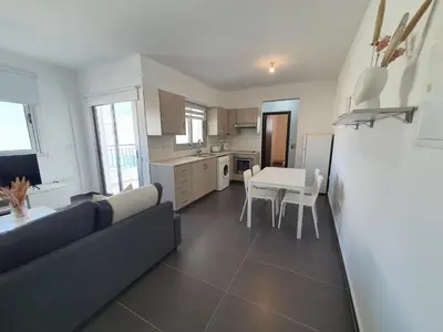a kitchen and living room with a couch and a table at Phaedrus Living: City Center Cozy Flat Demetra 102 in Larnaka