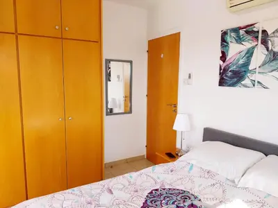 a bedroom with a bed and wooden cabinets at Liopetri 2-Bed Apt Sleeps 6 Pool 10min to Beach in Liopetri